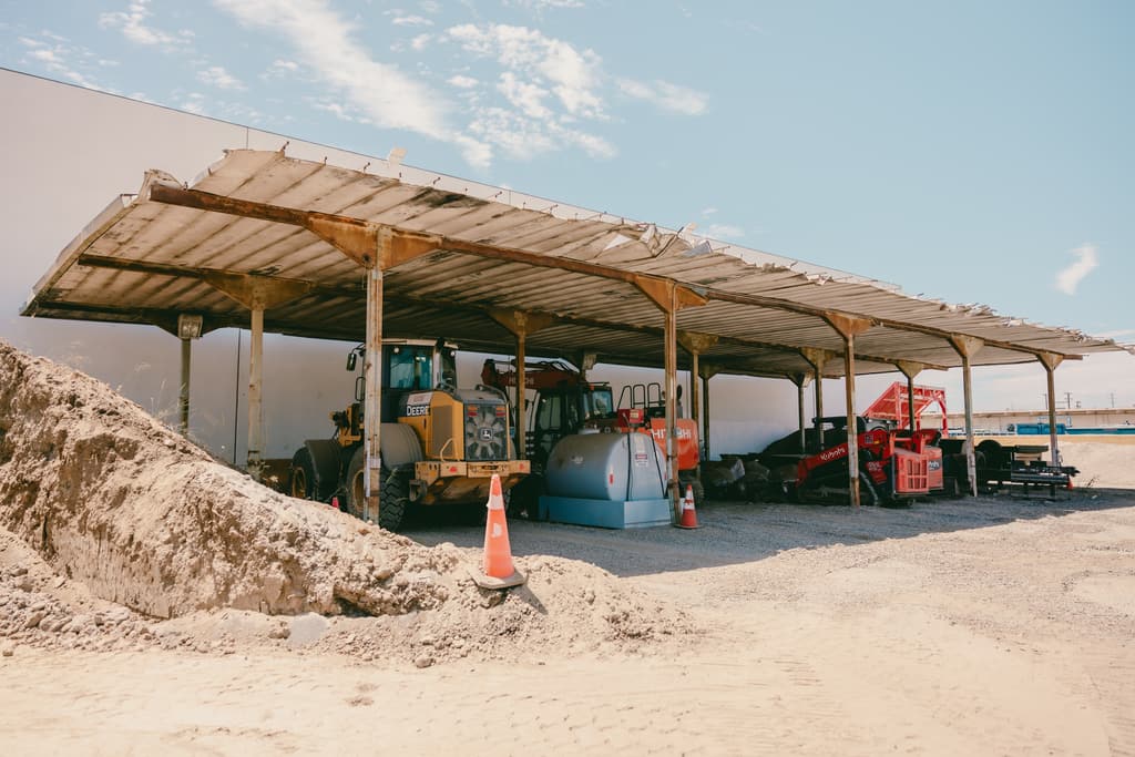Covered equipment bay with machines parked next to a stockpile